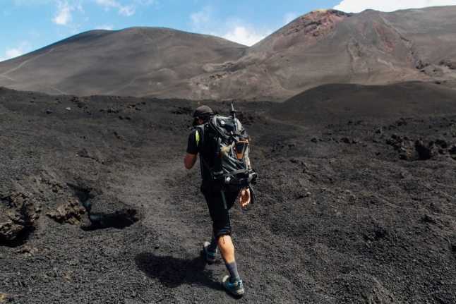 Our guest is climbing Mount Kilimanjaro, making their way up the rocky slopes toward the snow-capped summit under the clear Tanzanian sky.